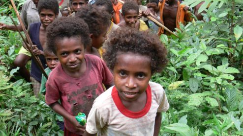 A group of Indonesians, mainly children, in a forest