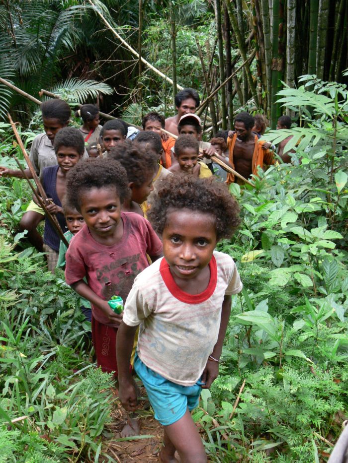 A group of Indonesians, mainly children, in a forest