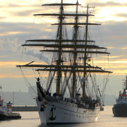 Traditional Germany Navy training vessel the Gorch Fock in the water straddled by two barges