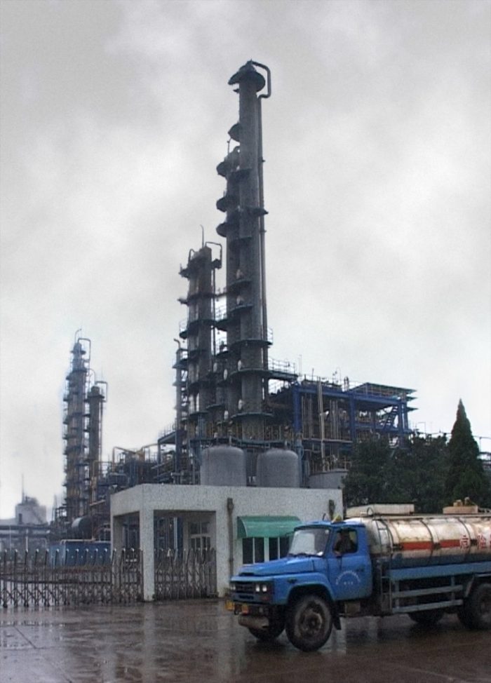 A fuel truck passing by a factory